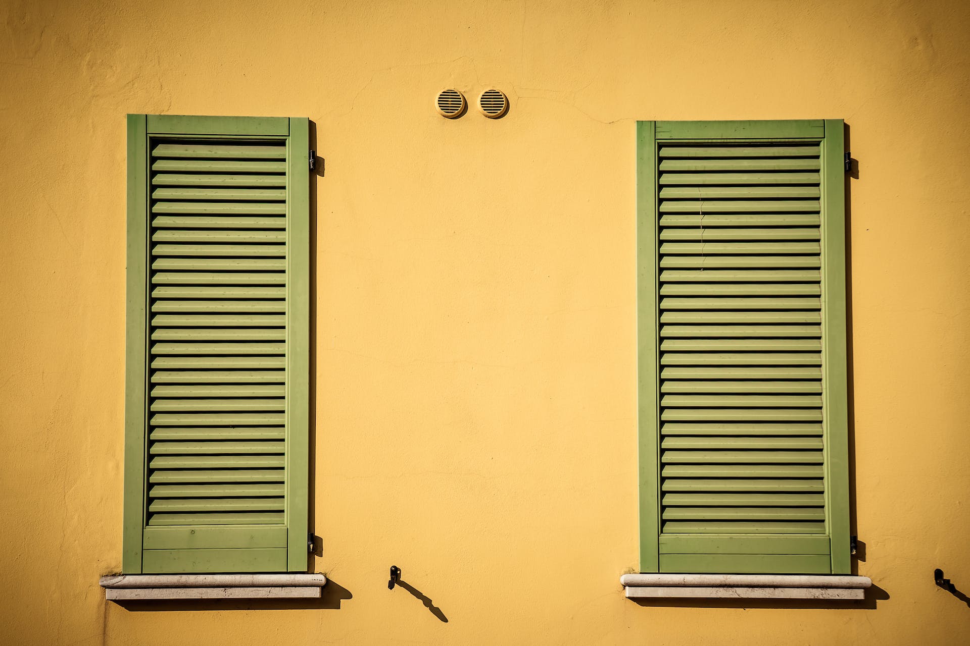 A pair shutters for windows from the outside closed over the window opening
